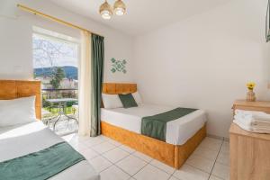 a bedroom with two beds and a balcony at Chrissi Ammoudia in Toroni
