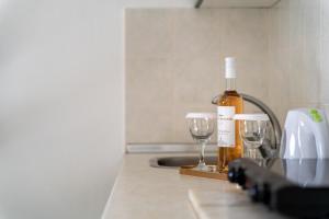 a bottle of wine and two wine glasses on a counter at Chrissi Ammoudia in Toroni