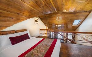 a bed in a room with a wooden ceiling at Summit Grace Boutique Hotel & Spa in Darjeeling