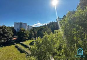 a sun shining on a hill with trees and a building at Deer Room - 5 Minutes to Sopot Molo & Seaside in Sopot