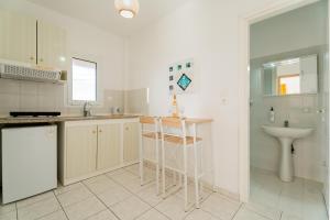 a white kitchen with a sink and a counter at Chrissi Ammoudia in Toroni +175 photos