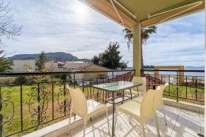 a balcony with a table and chairs and a view of the water at Chrissi Ammoudia in Toroni