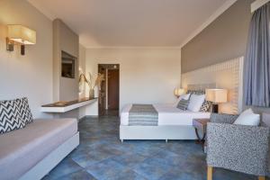 a hotel room with a bed and a couch at Lindos Imperial Resort & Spa in Kiotari