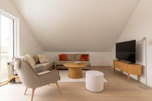 a living room with a couch and a tv at Sunlit Loft Apartment in Valby with Parking for 8 in Copenhagen