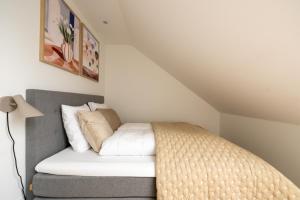 a bed with white sheets and pillows in a room at Sunlit Loft Apartment in Valby with Parking for 8 in Copenhagen +42 photos