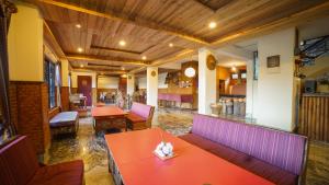 a restaurant with red tables and purple chairs at Bamboo Retreat Hotel in Gangtok