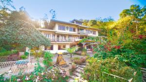 a large house with a garden in front of it at Bamboo Retreat Hotel in Gangtok
