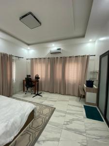 a bedroom with a bed and a desk and a chair at Le grand luxe in Cotonou
