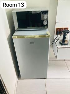 a microwave oven sitting on top of a refrigerator at The Bright Guest House in Pretoria