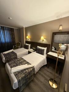 a hotel room with two beds and a desk at Green Anka Hotel in Istanbul