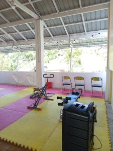 a gym with chairs and exercise equipment in a room at M2 Homestay Berastagi in Berastagi