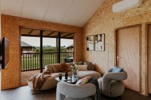 a living room with a couch and a table and chairs at Dutchen Erfgoedpark De Hoop Glamping, Appartementen & Cottages in Uitgeest
