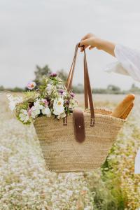 a person holding a basket of flowers in a field at Katrina Summer House in Jūrmalciems