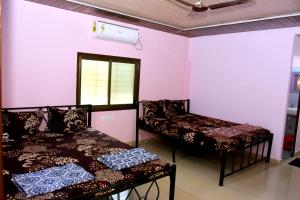 a room with two beds and a window at Nivant Agro Experience in Gorhe