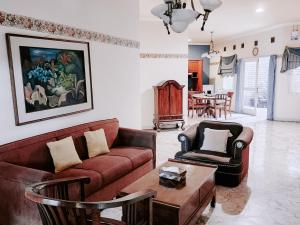 a living room with a couch and chairs and a table at Kulem Cisitu in Bandung