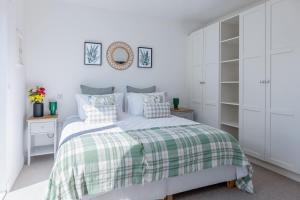 a bedroom with a bed with a green and white blanket at River View - Prime River Front Location in Seaton