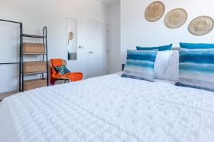 a bedroom with a large white bed and a chair at River View - Prime River Front Location in Seaton