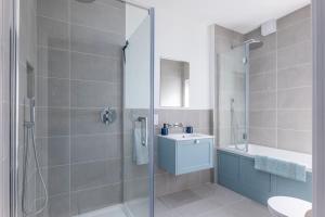 a bathroom with a shower and a toilet and a sink at River View - Prime River Front Location in Seaton +15 photos