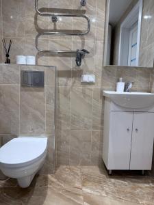 a bathroom with a toilet and a sink and a shower at EVA apartment in Marijampolė +9 photos