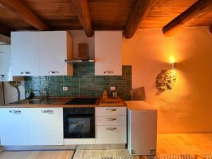 a kitchen with white cabinets and a stove top oven at Lilla Stuga in Montenero Val Cocchiara