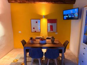 a dining room with a table and a yellow wall at Lilla Stuga in Montenero Val Cocchiara