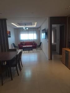 a living room with a red couch and a table at Al Anouar 39B in Kenitra +11 photos