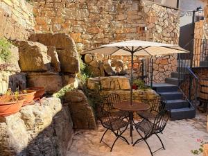 a table with an umbrella next to a stone wall at Lilla Stuga in Montenero Val Cocchiara