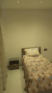 a bedroom with a bed and a night stand at Al Anouar 39B in Kenitra