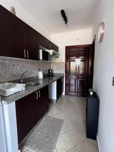 a kitchen with a sink and a counter with a door at Cabo Dream 71 in Cabo Negro