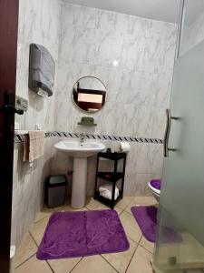 a bathroom with a sink and a mirror and purple mats at Cabo Dream 71 in Cabo Negro +12 photos
