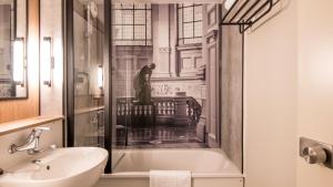 a bathroom with a bath tub and a sink at Campanile NATURE - Strasbourg Sud Geispolsheim in Geispolsheim