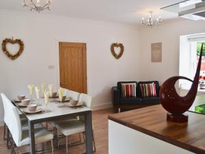 a kitchen and dining room with a table and chairs at Ladybird Cottage in Lochend