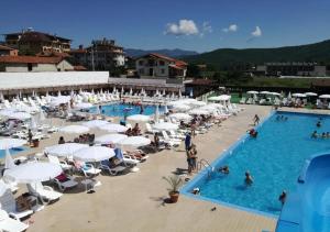 a large pool with white umbrellas and people in it at Апартамент Боров рай in Velingrad