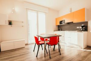 a kitchen with a table and two red chairs at AL 13 - Lakeside Leisure & Business in Stresa