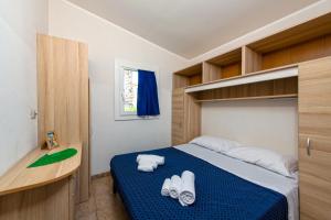 a bedroom with a bed with towels on it at Village Lake Placid in Silvi Marina