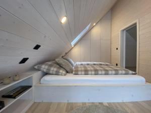a bed in a small room with a ceiling at Chalet Belveder SPORT in Železná Ruda