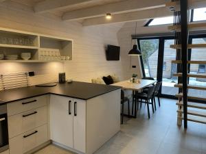 a kitchen with white cabinets and a table with chairs at Chalet Belveder SPORT in Železná Ruda +10 photos