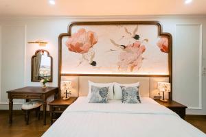 a bedroom with a bed with a large painting above it at OCEAN HOTEL Ninh Binh - Near Trang An & Hoa Lư Old Town in Kỳ Vĩ
