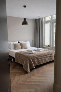 a bedroom with a bed and a pendant light at Boutique Hotel De Grote Kade in Goes