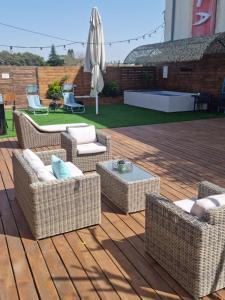 a patio with wicker chairs and a table and an umbrella at סוויטת בית ינאי in Beit-Herut