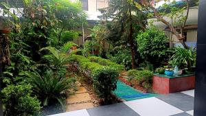 a garden with trees and plants in front of a building at Homestay Urmil Basant in Jaipur