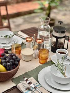a table with plates of food and a bowl of fruit at Fig Tree Rock 2-bed, 2-bath villa with garden and parking in Nelspruit