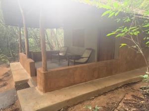 a porch with two chairs and a table at Kamatha Eco Lodge in Habarana