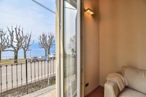 a living room with a sliding glass door to a balcony at Jolie Maison by Villa Porta Collection in Luino +5 photos