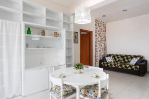 a living room with a white table and a couch at San Menaio Apartment by Rentbeat in San Menaio +27 photos