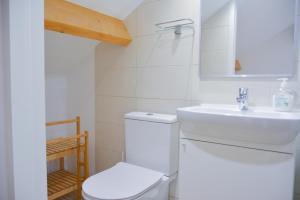 a white bathroom with a toilet and a sink at OportoWaves in Matosinhos +101 photos