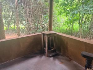 a small wooden table in front of a window at Kamatha Eco Lodge in Habarana