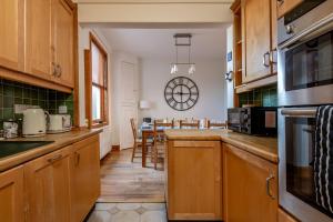 a kitchen with wooden cabinets and a dining room at Dylsford - Elie in Elie