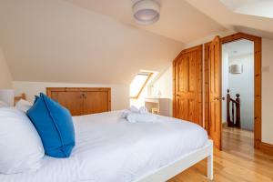 a bedroom with a white bed with blue pillows at Dylsford - Elie in Elie