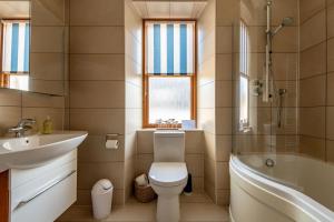 a bathroom with a toilet and a sink and a tub at Dylsford - Elie in Elie +28 photos
